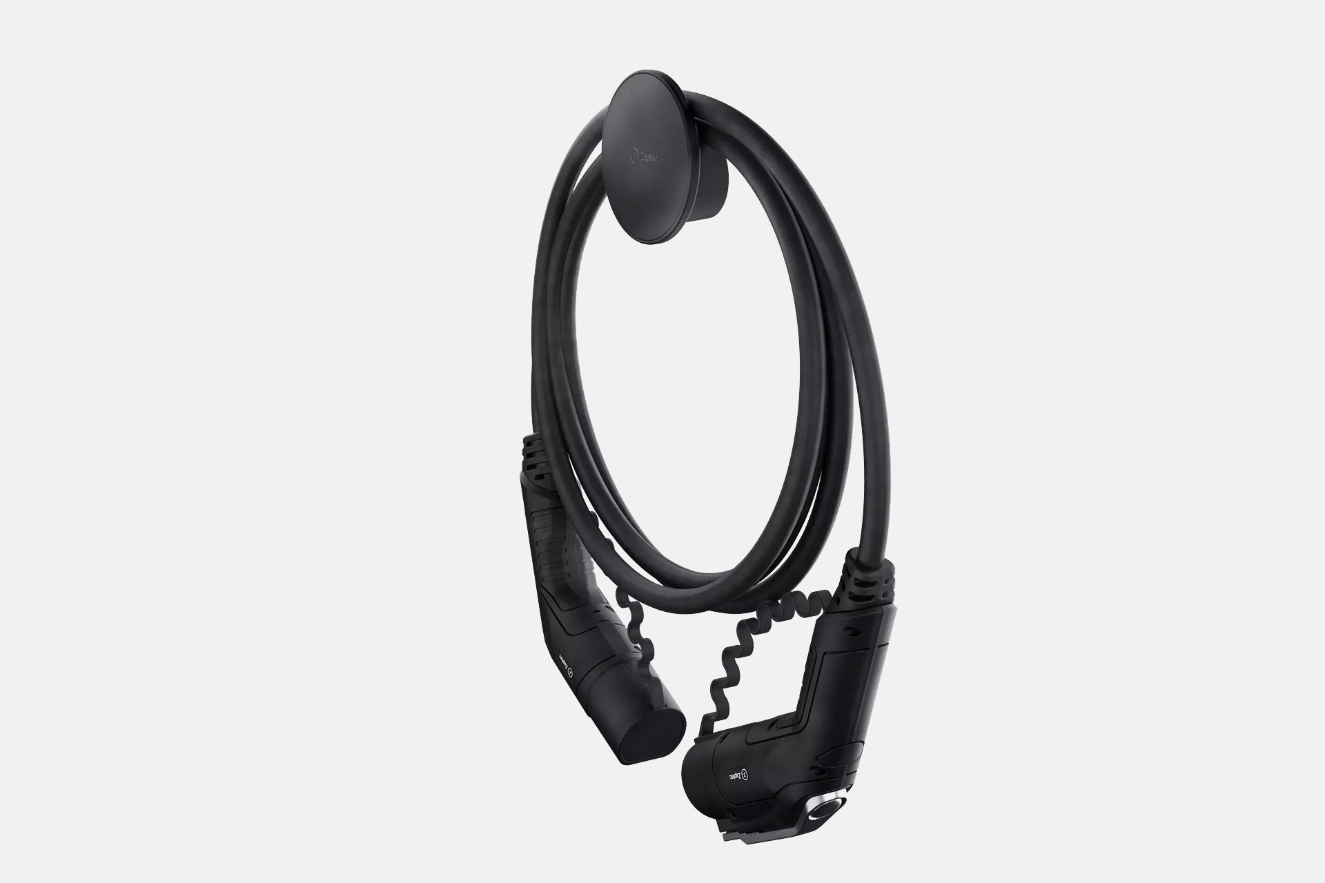 Elegantes Design: Die Zaptec Chill Kabelhalterung von Zaptec präsentiert ein schwarzes Ladekabel für Elektrofahrzeuge, ordentlich auf einem runden Halter an der Wand – ein stilvoller Blickfang vor schlichtem Hintergrund.