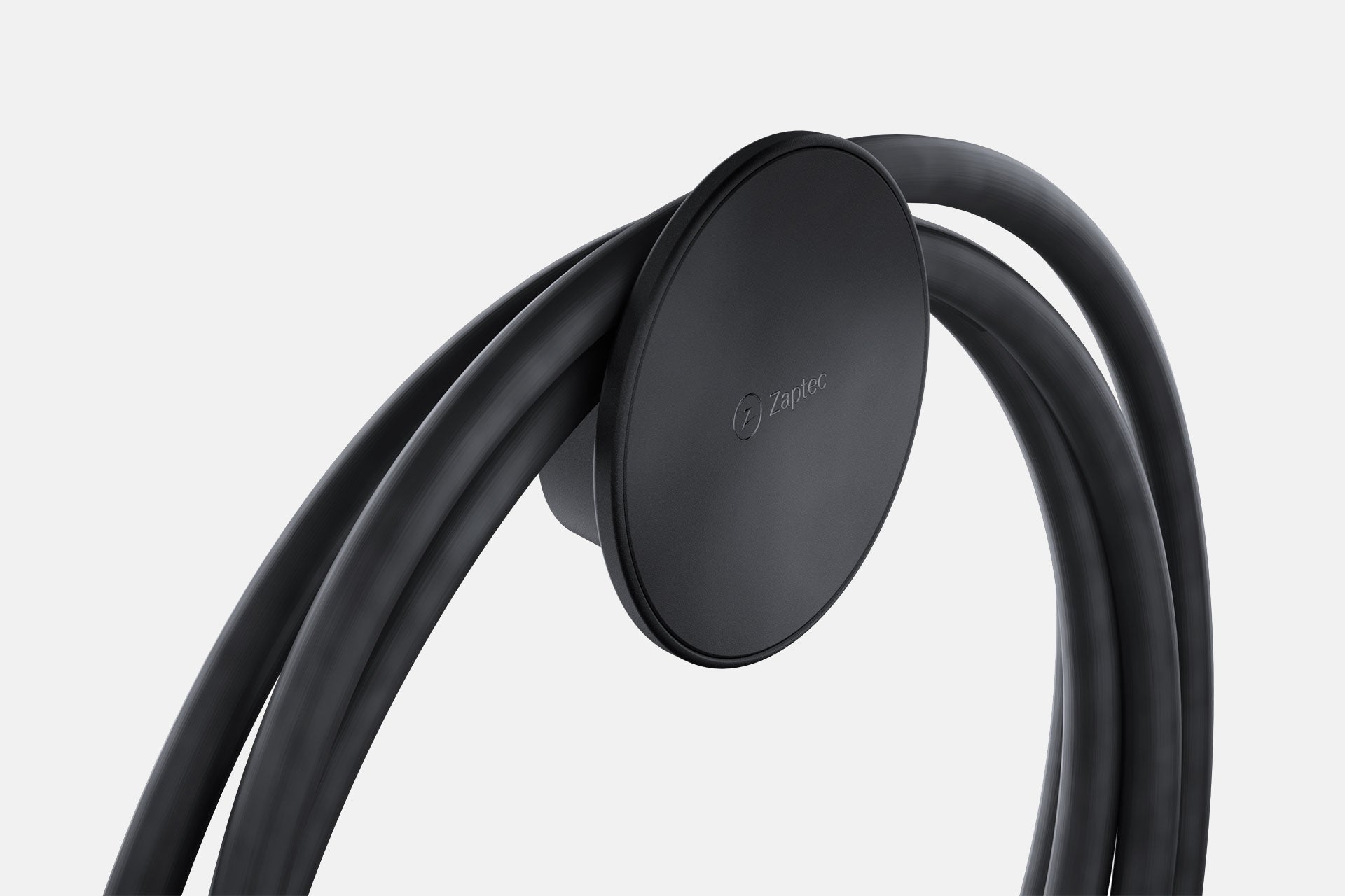 Eine Nahaufnahme der Zaptec Chill (Kabelhalterung) von Zaptec mit elegantem Design, die ein aufgewickeltes schwarzes Ladekabel ordentlich vor einem schlichten hellen Hintergrund organisiert.